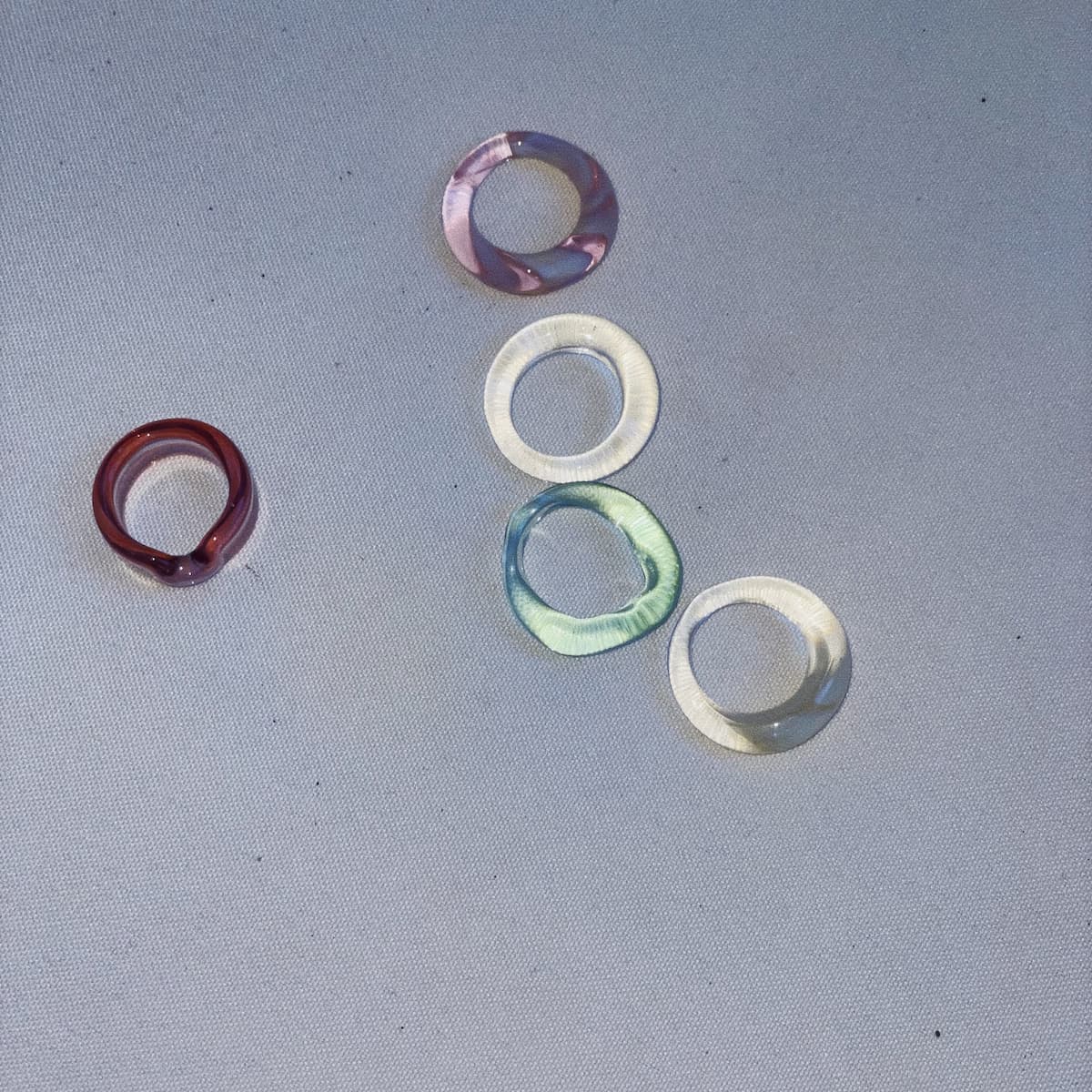 Set of colorful glass rings on a gray background