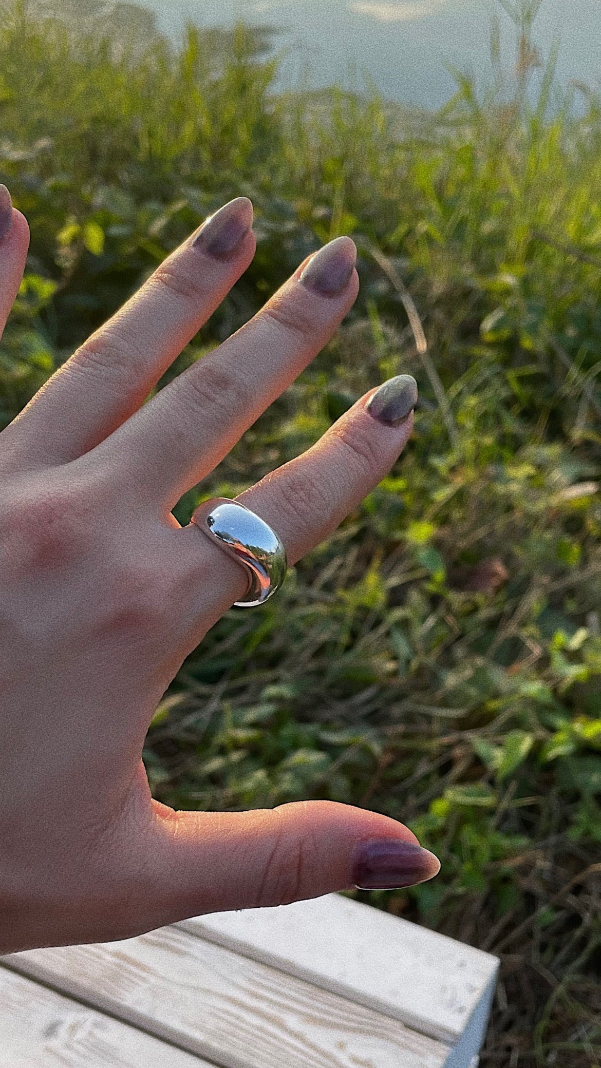 all rivers high wave ring worn by woman in front of a lake
