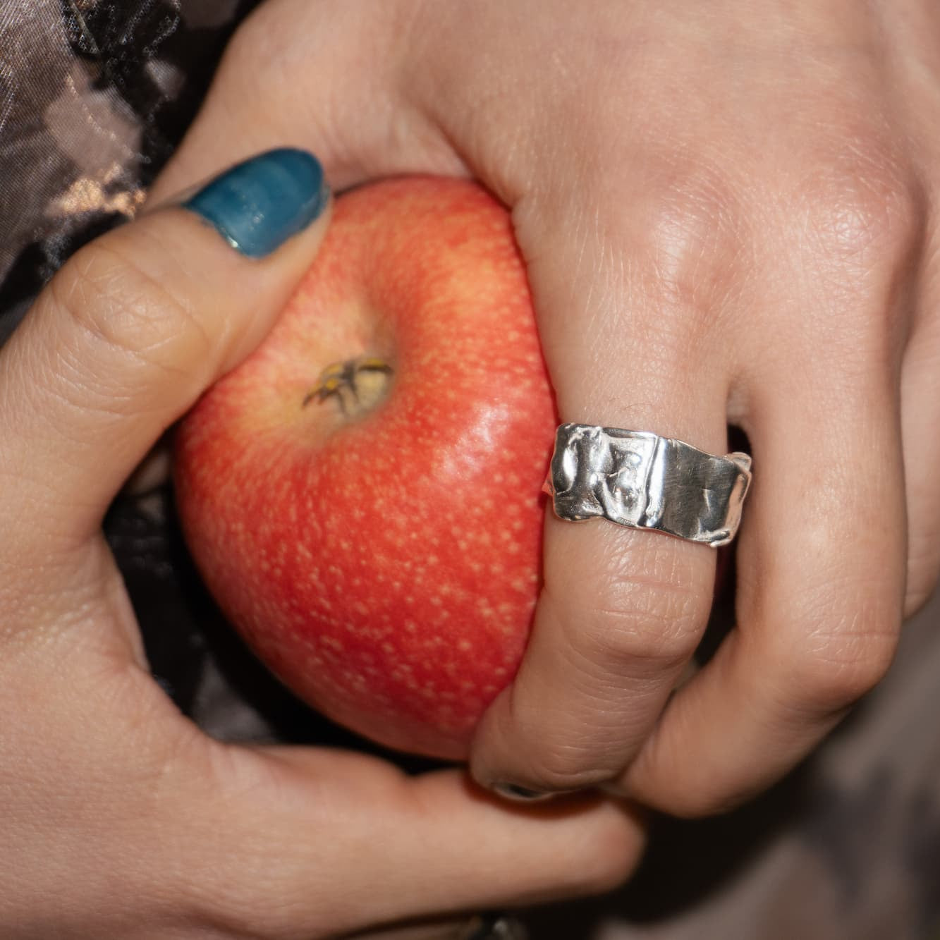 All Rivers Jewelry called Yosun Ring hand holding an apple
